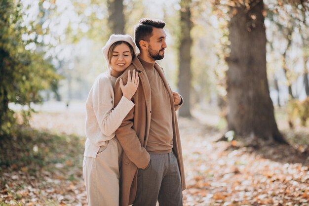 Joven pareja junto en un parque de otoño