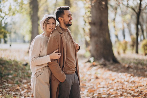 Joven pareja junto en un parque de otoño