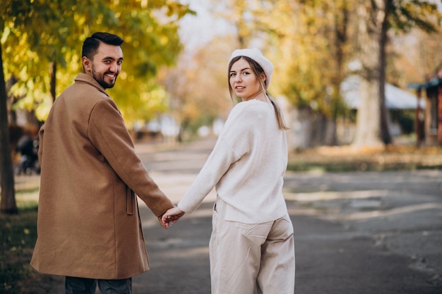 Joven pareja junto en un parque de otoño