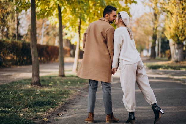 Joven pareja junto en un parque de otoño