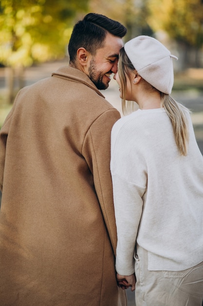 Joven pareja junto en un parque de otoño