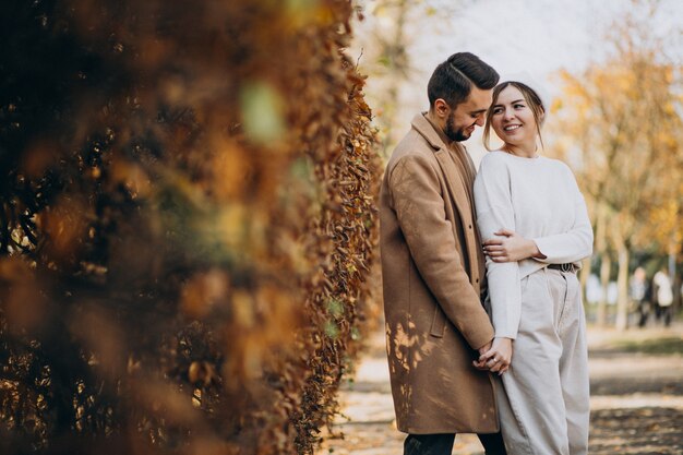 Joven pareja junto en un parque de otoño