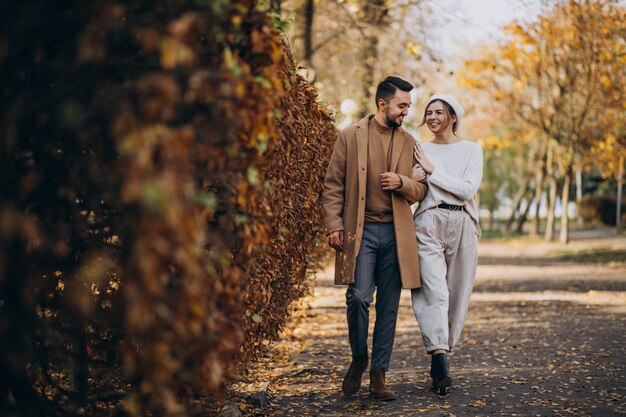 Joven pareja junto en un parque de otoño
