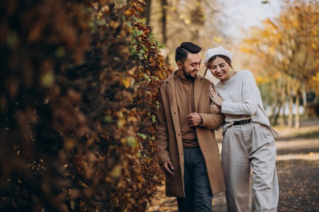 Joven pareja junto en un parque de otoño