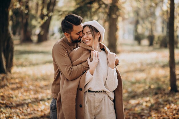 Joven pareja junto en un parque de otoño