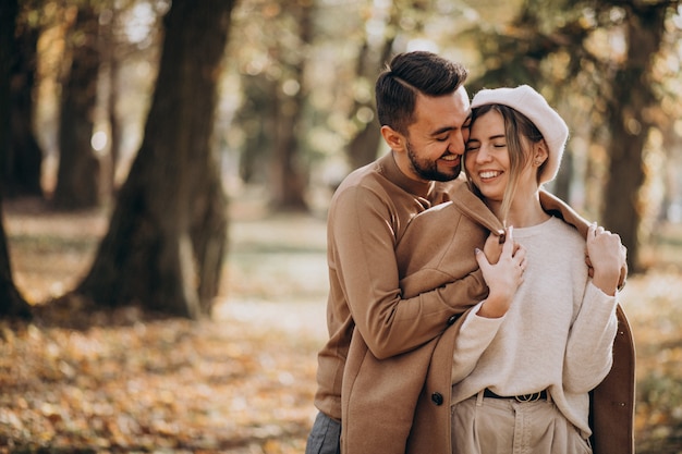 Joven pareja junto en un parque de otoño