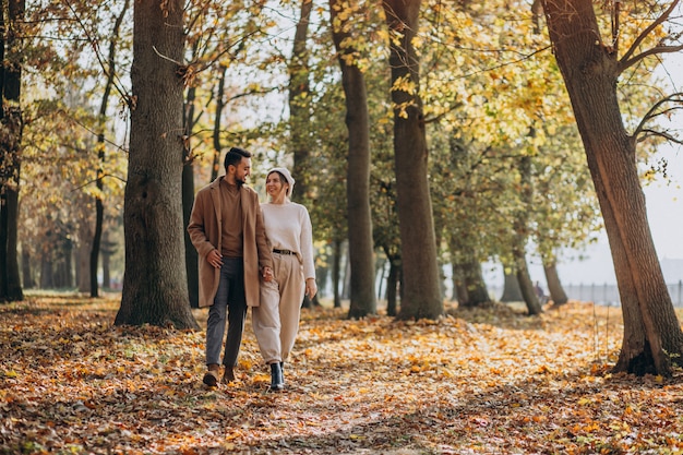 Joven pareja junto en un parque de otoño