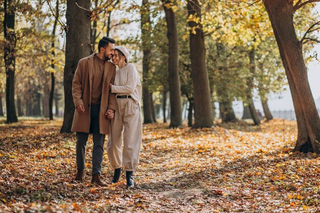 Joven pareja junto en un parque de otoño