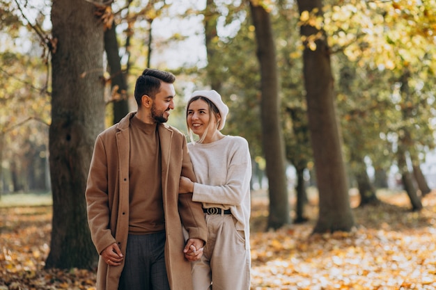 Joven pareja junto en un parque de otoño