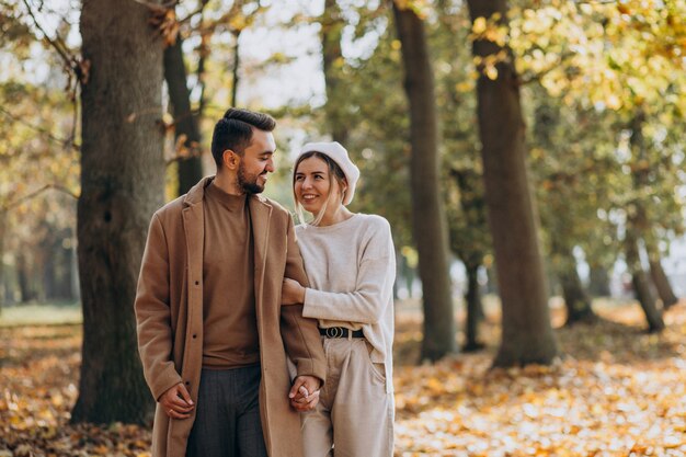 Joven pareja junto en un parque de otoño