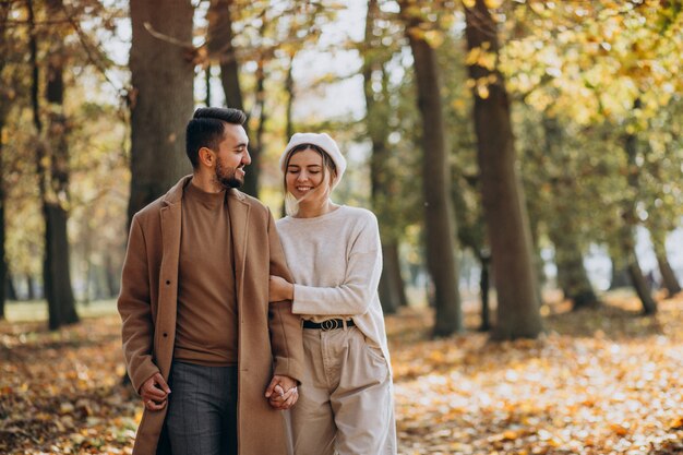 Joven pareja junto en un parque de otoño