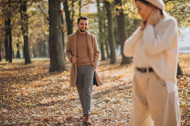 Joven pareja junto en un parque de otoño