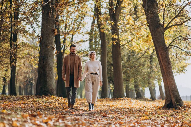 Joven pareja junto en un parque de otoño