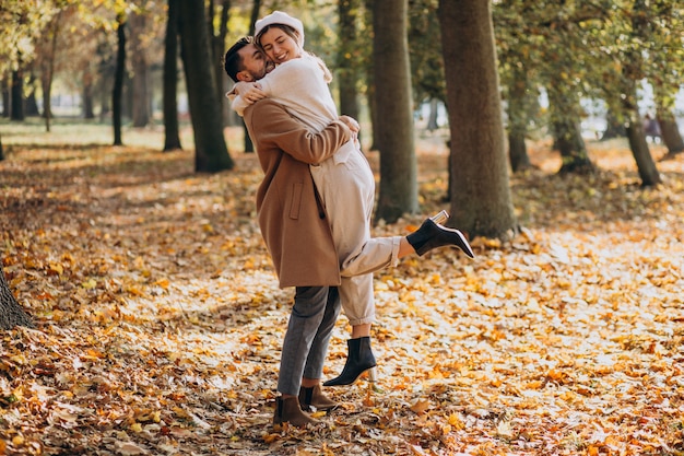 Joven pareja junto en un parque de otoño