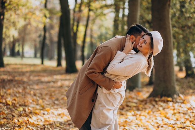 Joven pareja junto en un parque de otoño