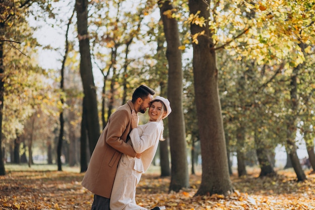 Joven pareja junto en un parque de otoño