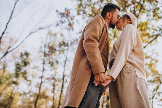 Joven pareja junto en un parque de otoño