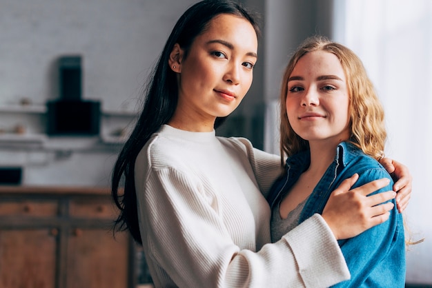 Joven pareja de lesbianas abrazando en casa