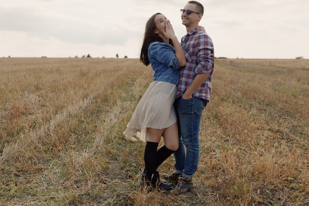 Joven pareja moderna con estilo al aire libre. Joven pareja romántica en el amor al aire libre en el campo