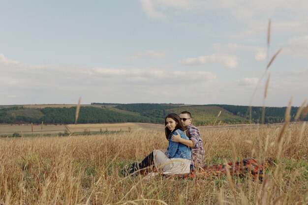 Joven pareja moderna con estilo al aire libre. Joven pareja romántica en el amor al aire libre en el campo