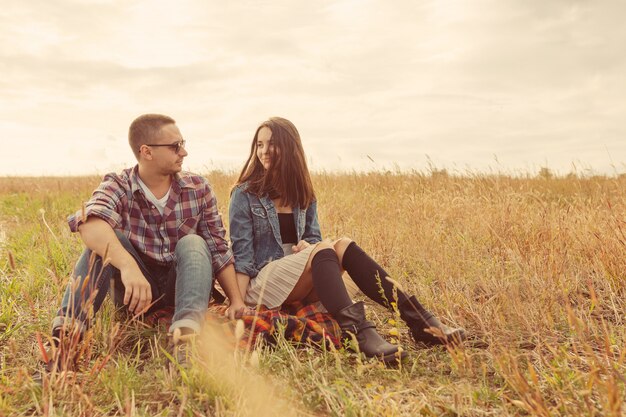 Joven pareja moderna con estilo al aire libre. Joven pareja romántica en el amor al aire libre en el campo