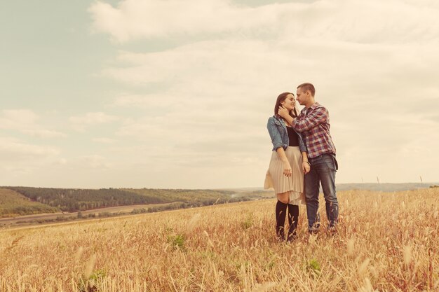 Joven pareja moderna con estilo al aire libre. Joven pareja romántica en el amor al aire libre en el campo