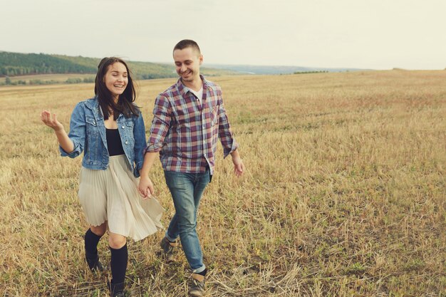 Joven pareja moderna con estilo al aire libre. Joven pareja romántica en el amor al aire libre en el campo