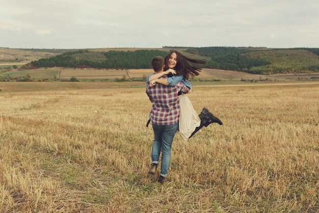 Joven pareja moderna con estilo al aire libre. Joven pareja romántica en el amor al aire libre en el campo