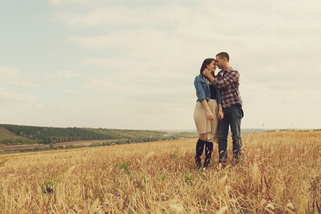 Joven pareja moderna con estilo al aire libre. Joven pareja romántica en el amor al aire libre en el campo