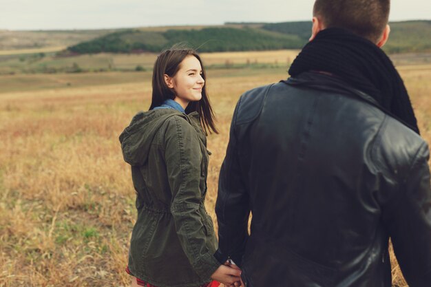 Joven pareja moderna con estilo al aire libre. Joven pareja romántica en el amor al aire libre en el campo