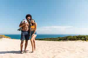 Foto gratuita joven pareja multirracial apoyándose el uno al otro en la playa