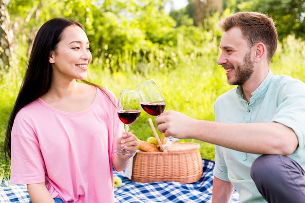 Joven pareja multirracial enamorada haciendo picnic en la naturaleza