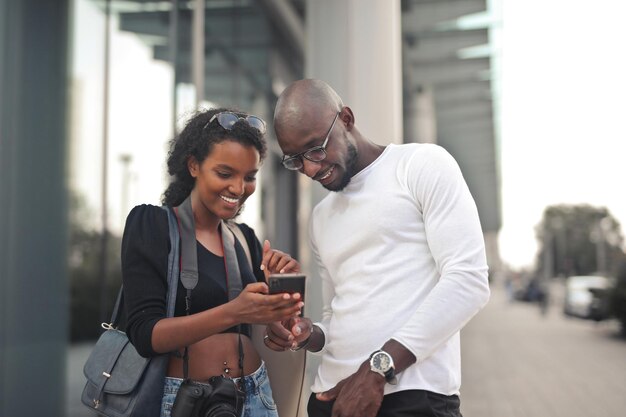 Joven pareja negra con un smartphone en la calle