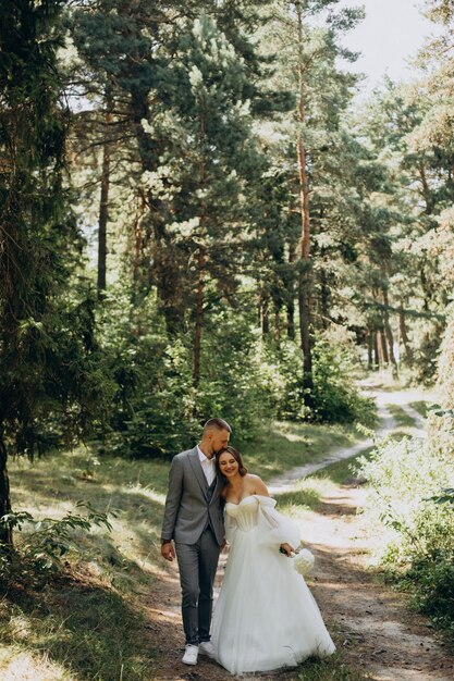 Joven pareja de novios con sesión de fotos en el bosque