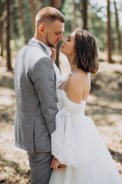 Joven pareja de novios con sesión de fotos en el bosque