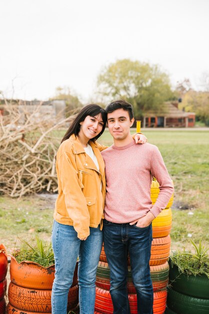 Joven pareja positiva abrazando en el parque otoño