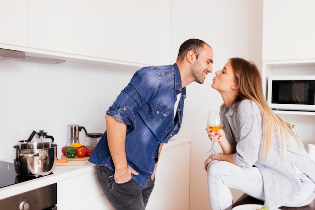 Joven pareja romántica besándose en la cocina