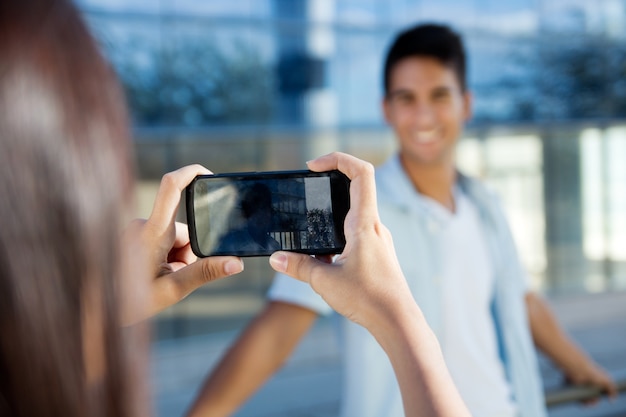 Joven pareja tomando fotos con móvil