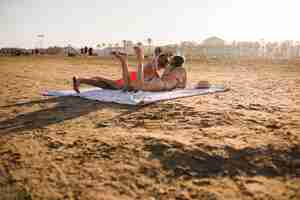 Foto gratuita joven pareja tomando el sol en la playa en vacaciones de verano