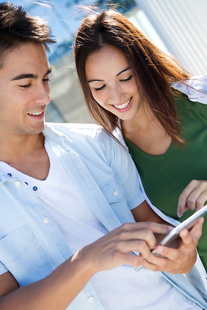 Foto gratuita joven pareja utilizando una tableta digital