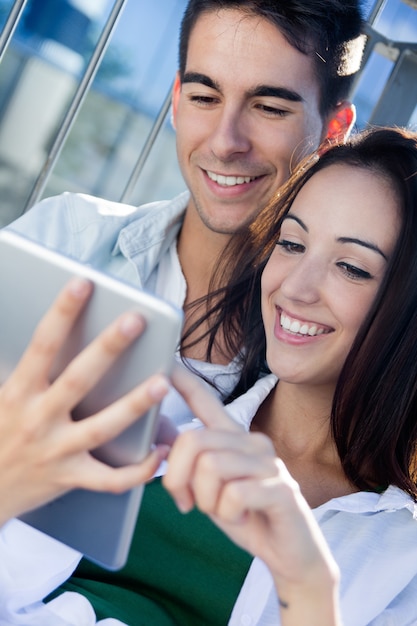 Foto gratuita joven pareja utilizando una tableta digital