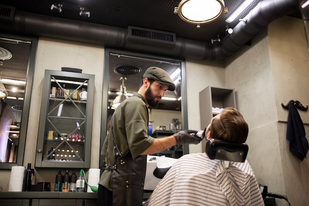 Joven en la peluquería recortándose la barba