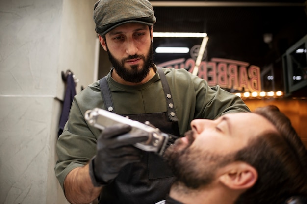 Foto gratuita joven en la peluquería recortándose la barba