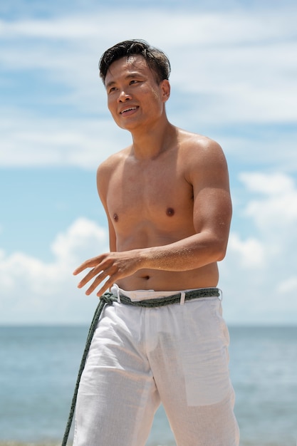 Joven en la playa preparándose para practicar capoeira