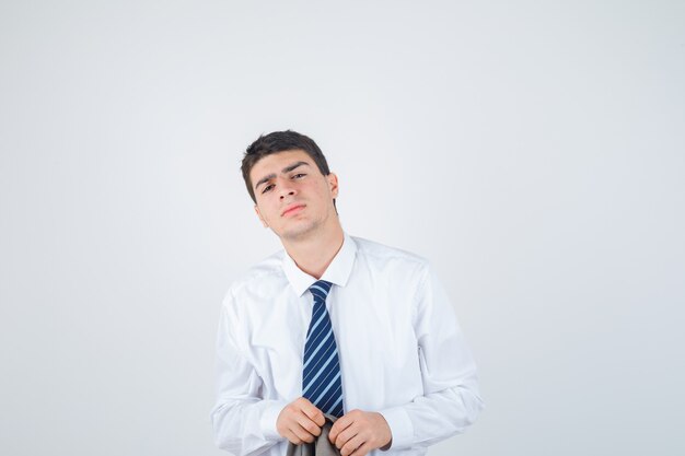 Joven posando con camisa blanca y corbata