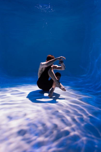 Joven posando sumergido bajo el agua