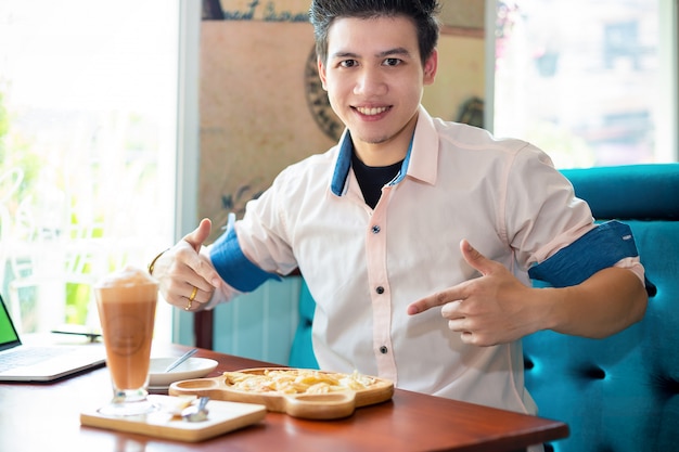 Joven con postre en cafetería