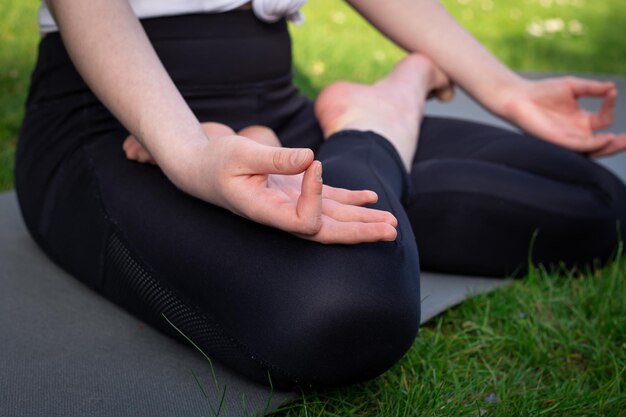 Una joven practica yoga en la naturaleza en el césped del patio.