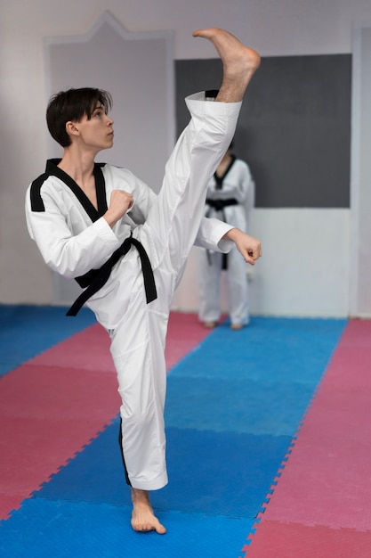 Foto gratuita joven practicando taekwondo en un gimnasio