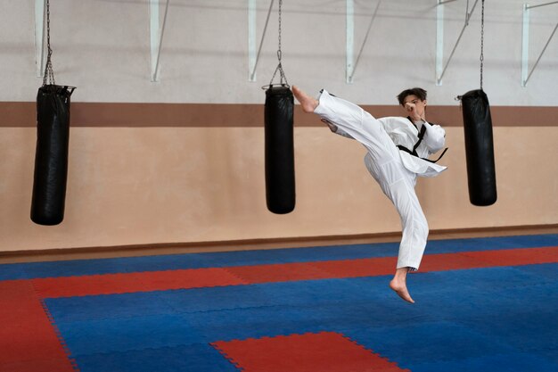Joven practicando taekwondo en un gimnasio